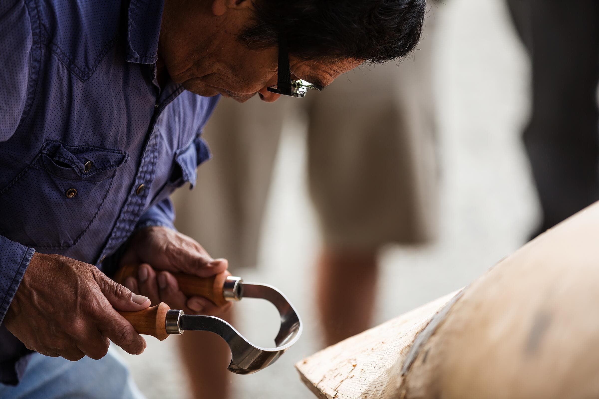 A First Nations carver shaping a dugout canoe near Tofino